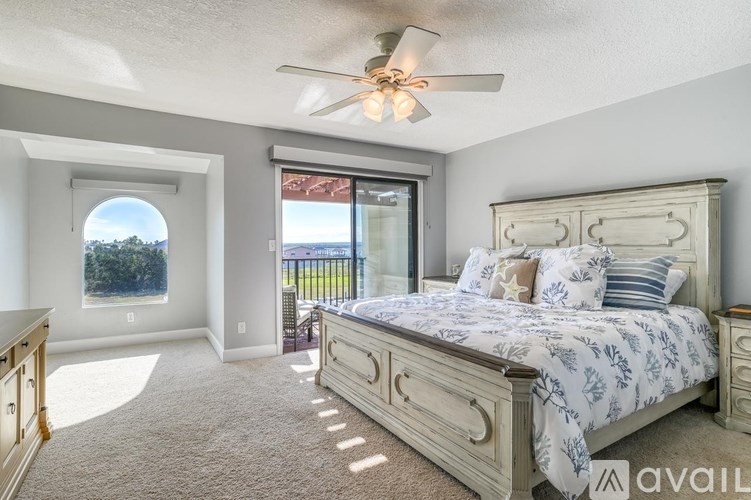 A bedroom with a large bed and a ceiling fan.