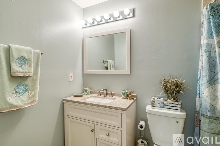 A bathroom with a sink, mirror, and toiletries.