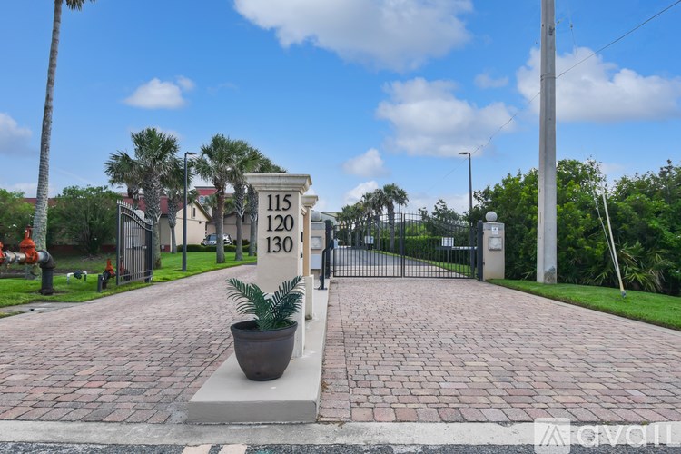 A brick pathway leads to a gate with a sign that reads 115 and 130.