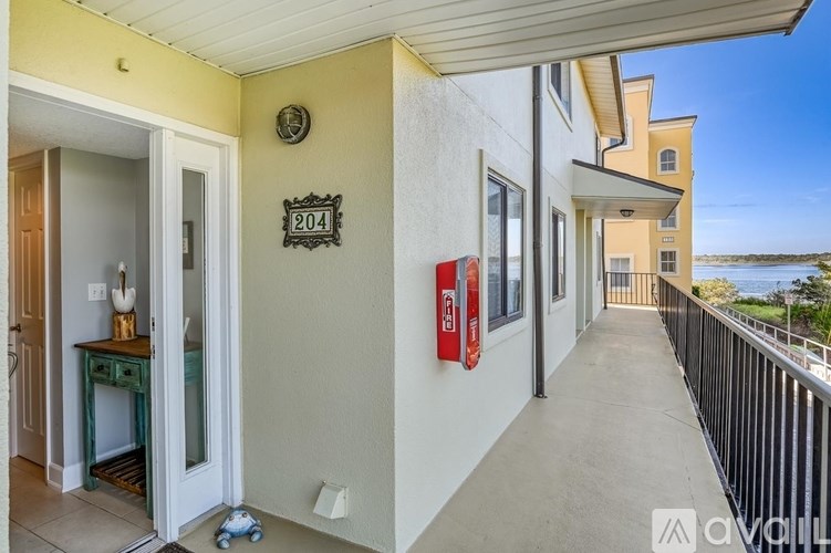 A balcony with a railing and a red fire extinguisher mounted on the wall.