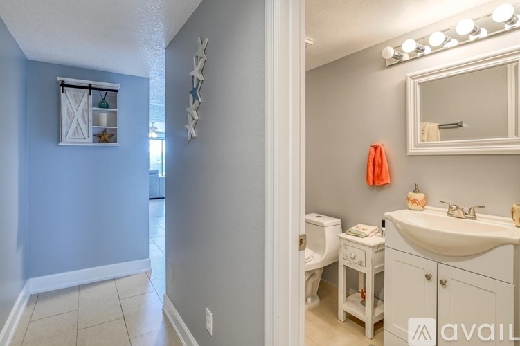 A bathroom with a toilet, sink, and mirror.