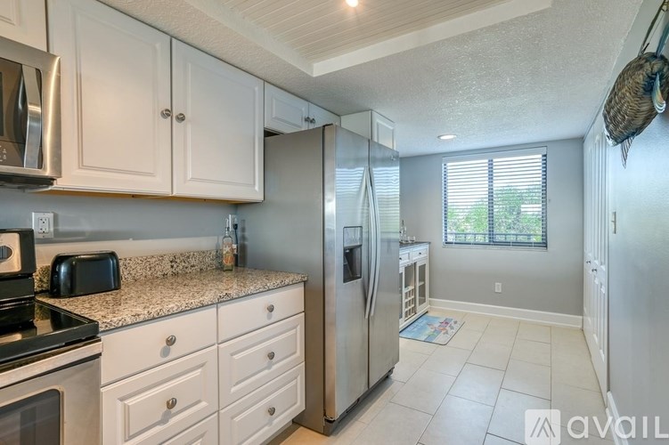 A kitchen with white cabinets and a granite countertop.