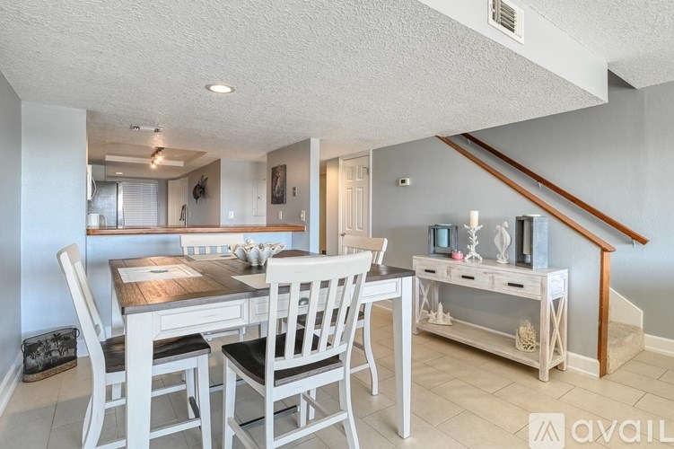 A dining room with a wooden table and chairs.