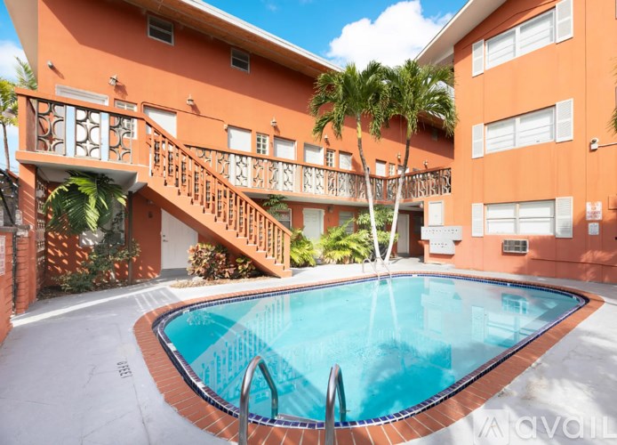 A small pool in front of a building with a staircase.