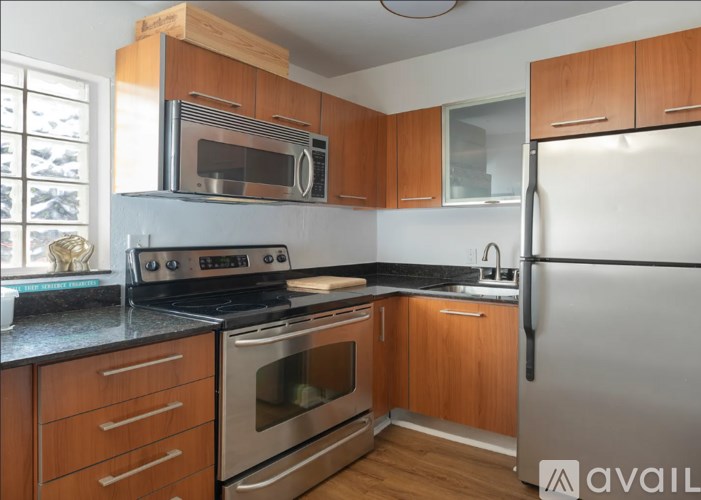 A kitchen with wooden cabinets and a black countertop.
