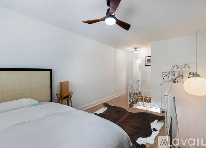 A bedroom with a large bed and a cowhide rug.
