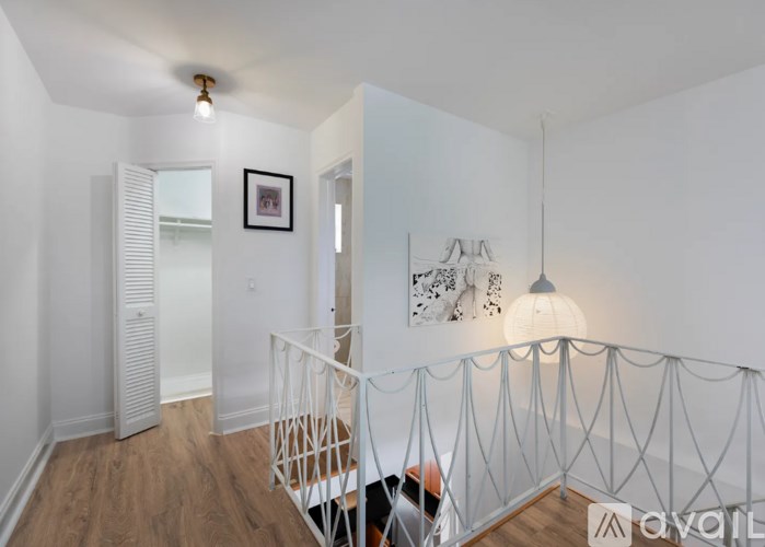 A room with a white railing and a painting on the wall.