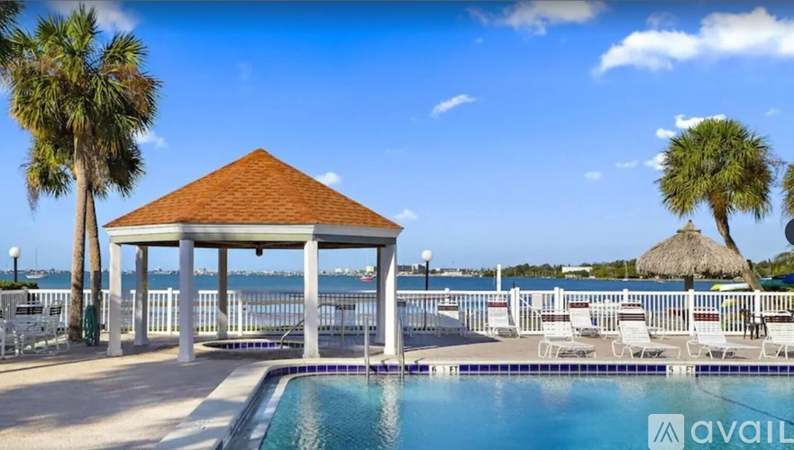 A pool area with a gazebo and palm trees.