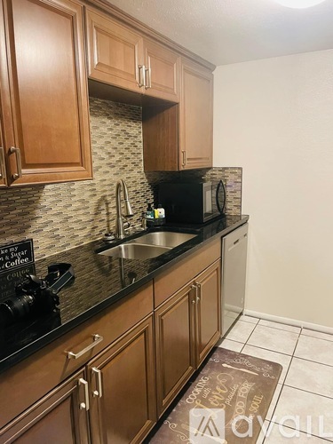 A kitchen with wooden cabinets and a black countertop.