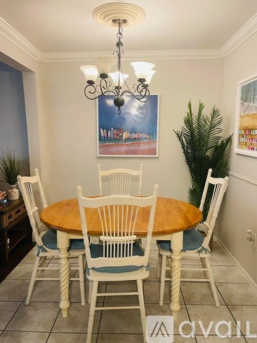 A dining room with a wooden table and chairs.