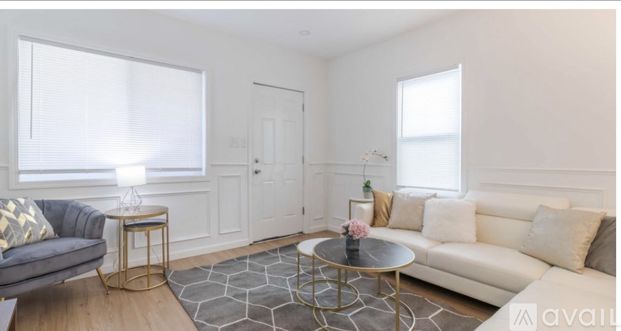 A living room with a grey sofa, a black coffee table, and a white couch.