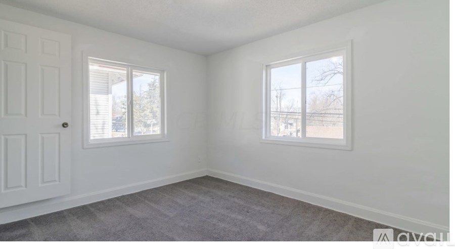 A white room with a door and two windows.