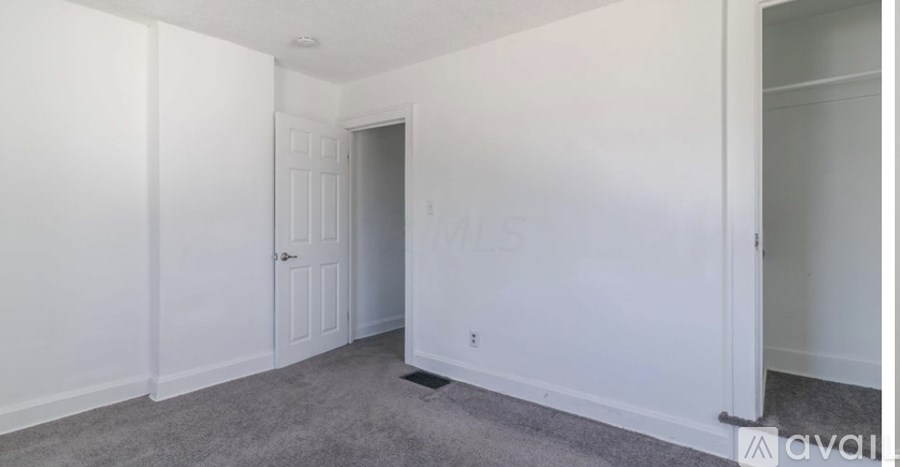 A room with a carpeted floor and a door.