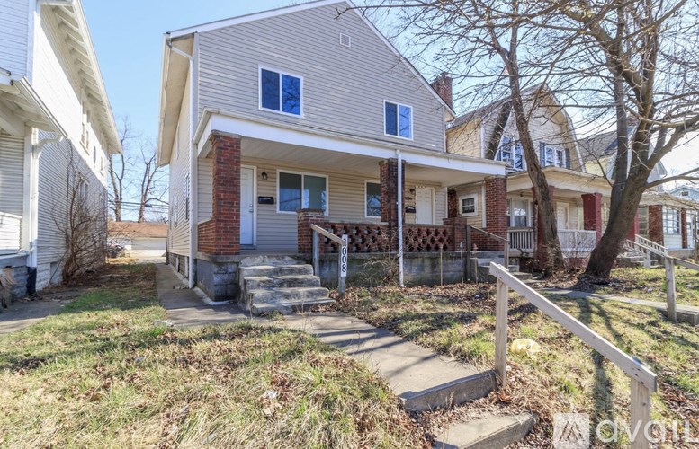 A house with a front porch and a tree in front.