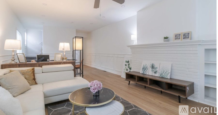 A living room with a white couch, a coffee table, and a fireplace.