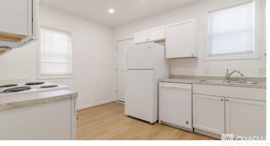A kitchen with white appliances and cabinets.