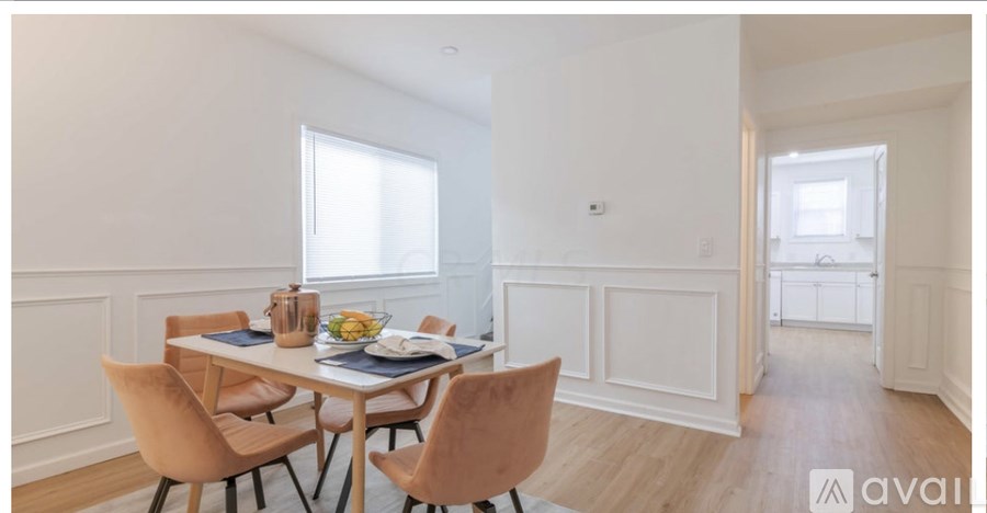 A dining room with a table set for two and chairs around it.