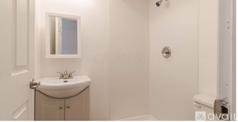 A white bathroom with a sink and a mirror.
