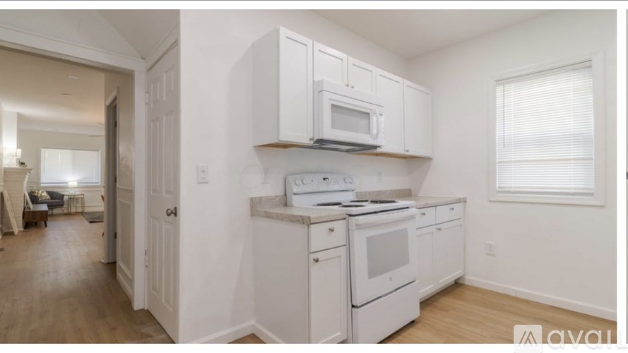 A kitchen with white cabinets and appliances.