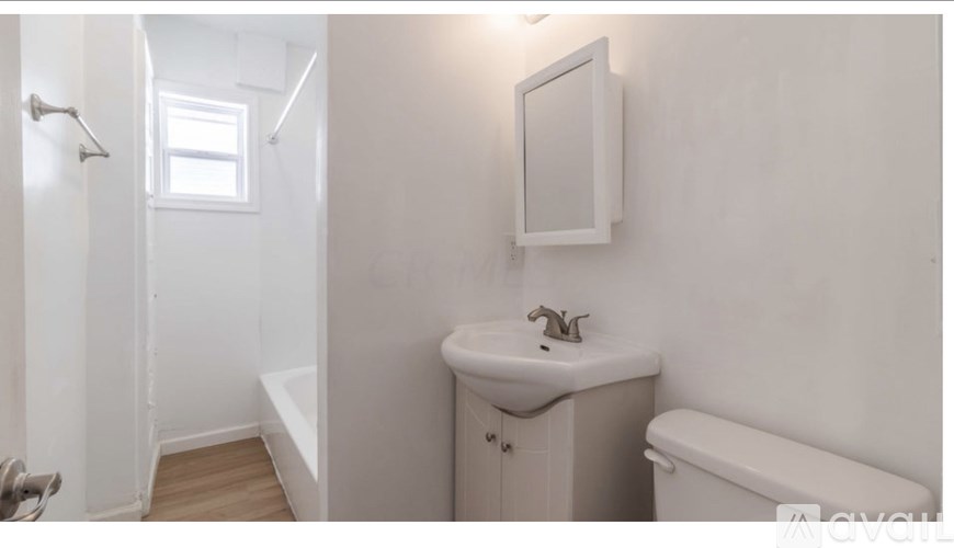 A white bathroom with a sink, toilet, and bathtub.
