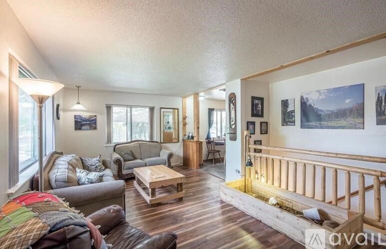 A living room with a couch, chair, and pictures on the wall.