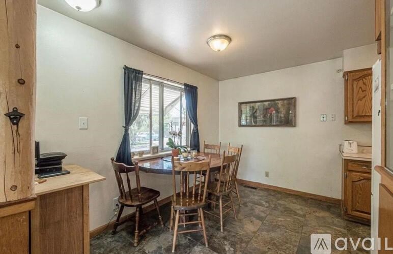 A dining room with a wooden table and chairs.
