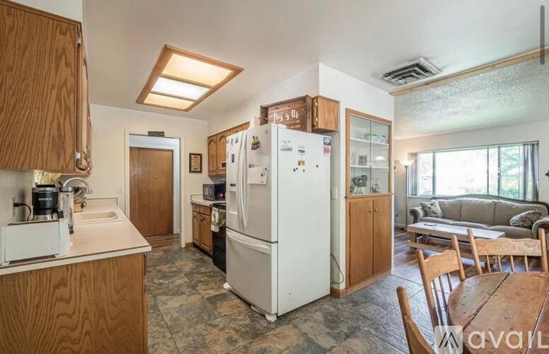 A kitchen with a refrigerator, sink, and cabinets.