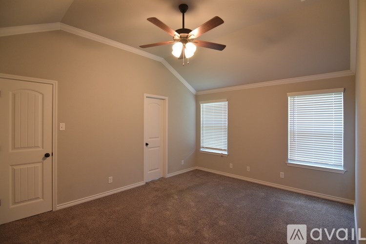 A room with a ceiling fan and carpeted floor.