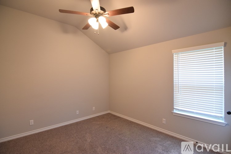 A room with a ceiling fan and a window with blinds.