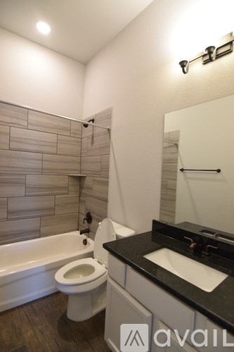 A bathroom with a tub, toilet and sink.