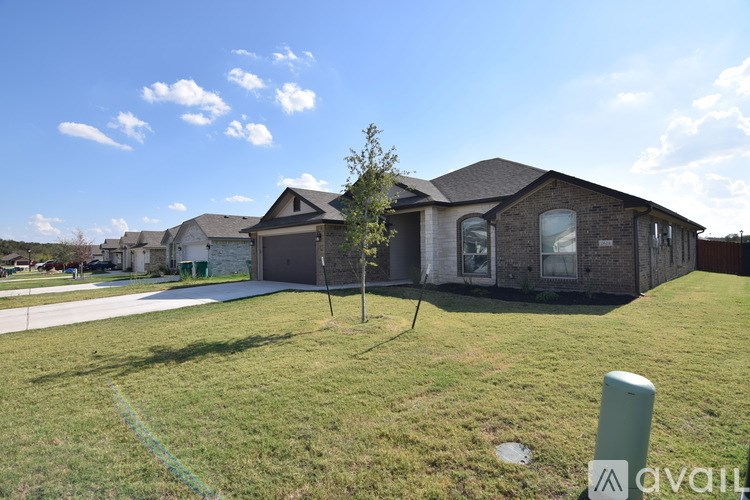 A house with a green lawn and a tree in front of it.