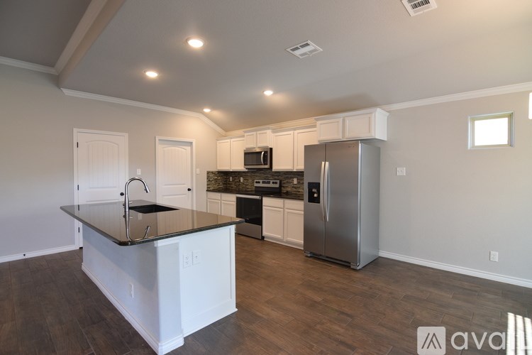 A kitchen with a black countertop and stainless steel appliances.