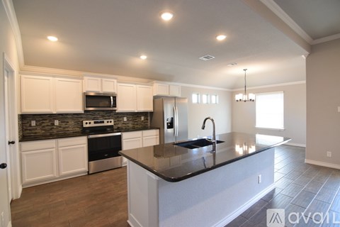 A kitchen with white cabinets and a black countertop.