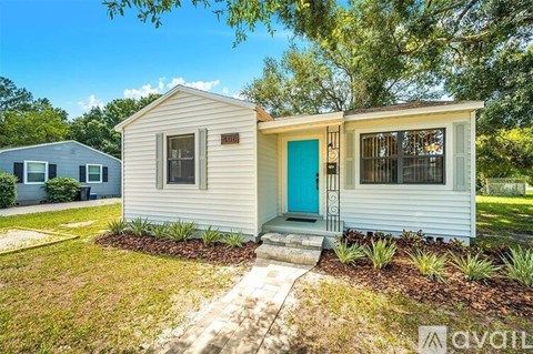 A small house with a blue door is for sale.