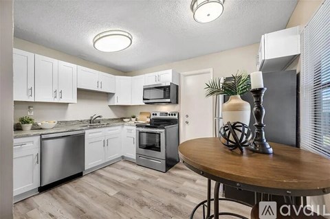 A kitchen with white cabinets and a wooden table.