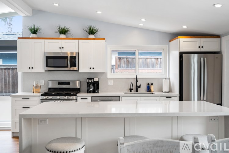 A modern kitchen with white cabinets and appliances.