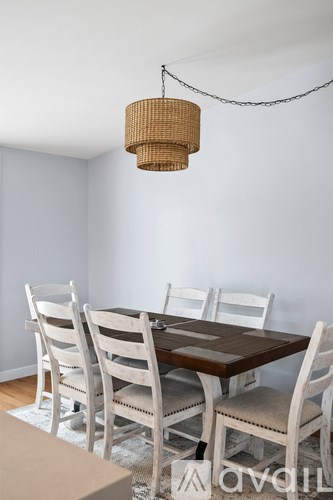 A dining room with a wooden table and chairs.