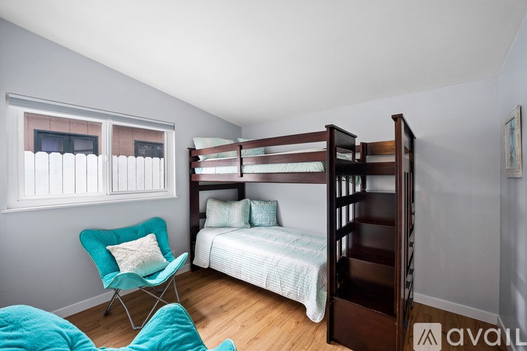 A bedroom with a bunk bed and a chair.