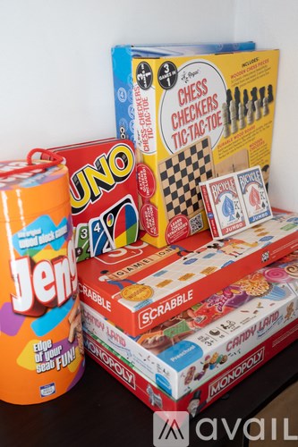 A collection of board games and a can of Jeno are stacked on top of each other.