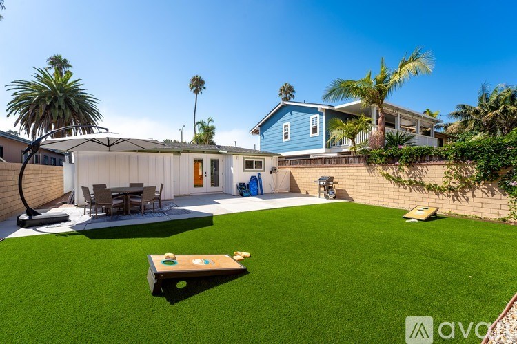 A backyard with a lawn and a table and chairs set up.