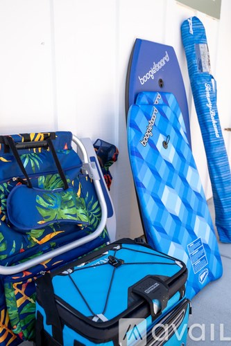 A blue suitcase with a tropical print and a blue and white checkered suitcase.