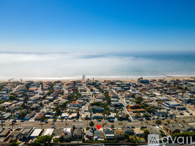 A red flag is flying in front of a row of houses.