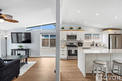 A modern kitchen with white cabinets and stainless steel appliances.