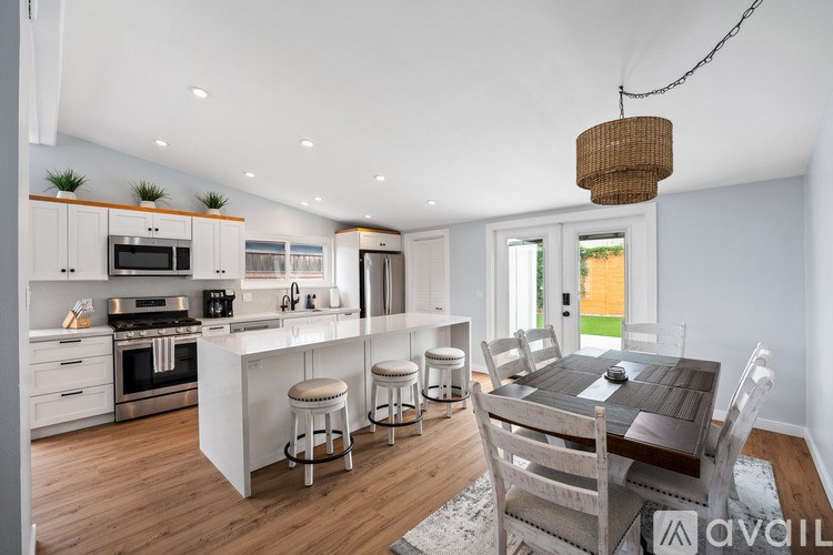 A modern kitchen with a dining table and chairs.
