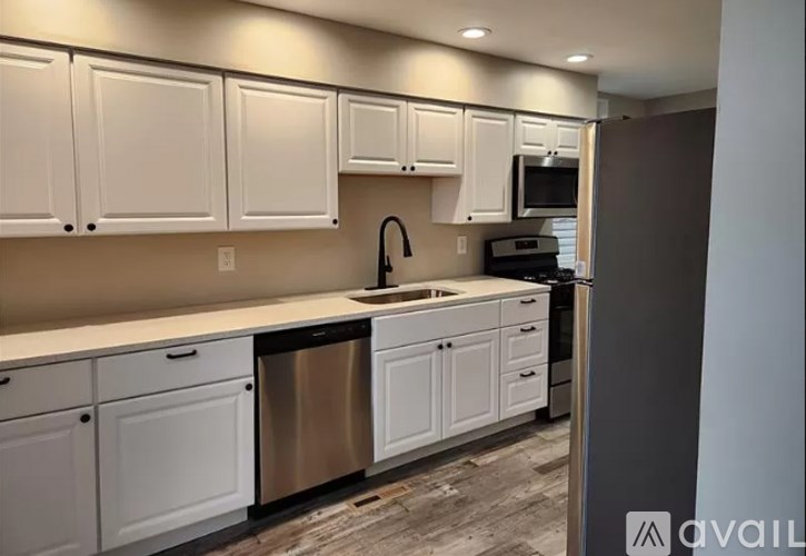 A kitchen with white cabinets and a stainless steel dishwasher.