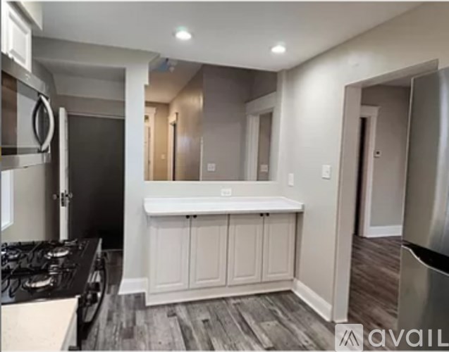 A kitchen with a black stove top oven and white cabinets.