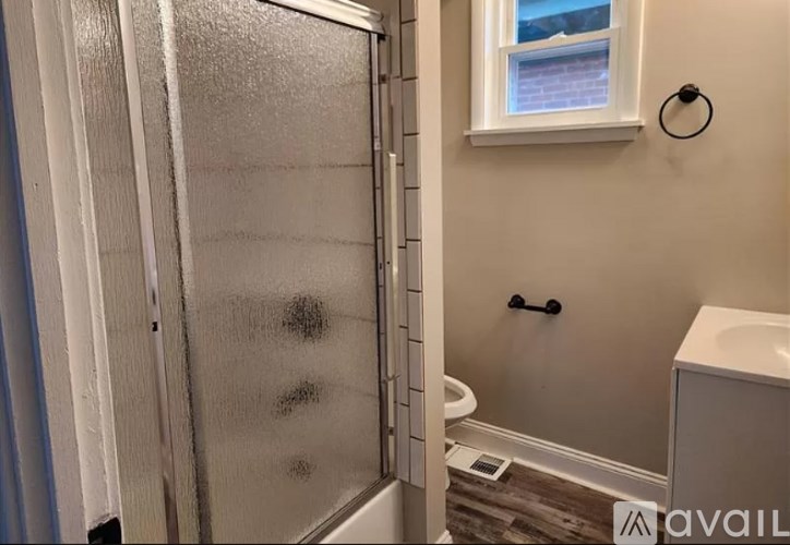 A bathroom with a glass shower door and a white sink.