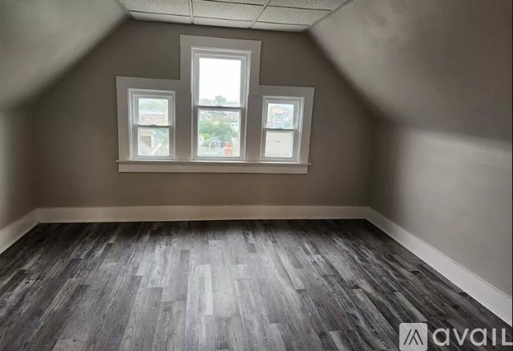 A room with a window and a wooden floor.