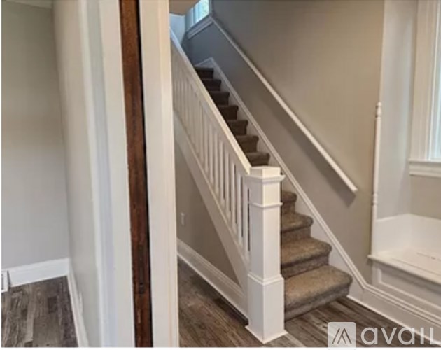 A staircase with white railings and a beige carpet.
