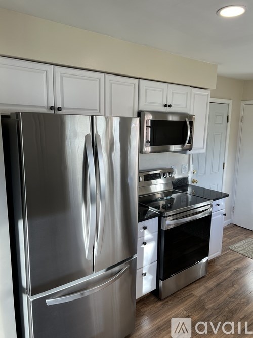A modern kitchen with a stainless steel refrigerator and microwave.